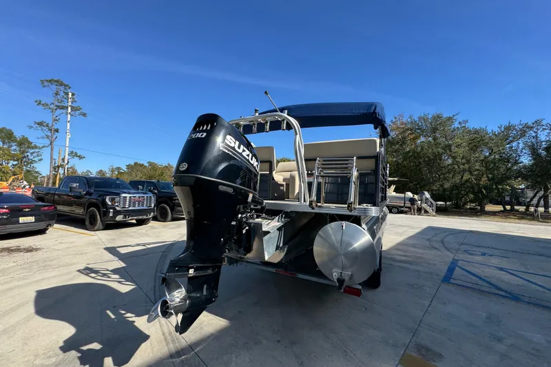 Slide: The Image of 2022 Crest Classic LX 240 SLRC pontoon boat with Suzuki outboard motor in parking lot. - 14