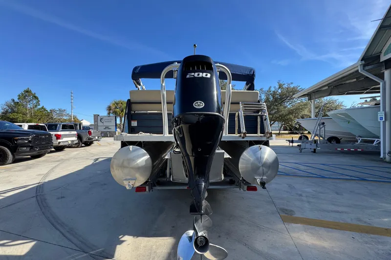 Slide: The Image of 2022 Crest Classic LX 240 SLRC pontoon boat with powerful outboard motor in a marina setting. - 15