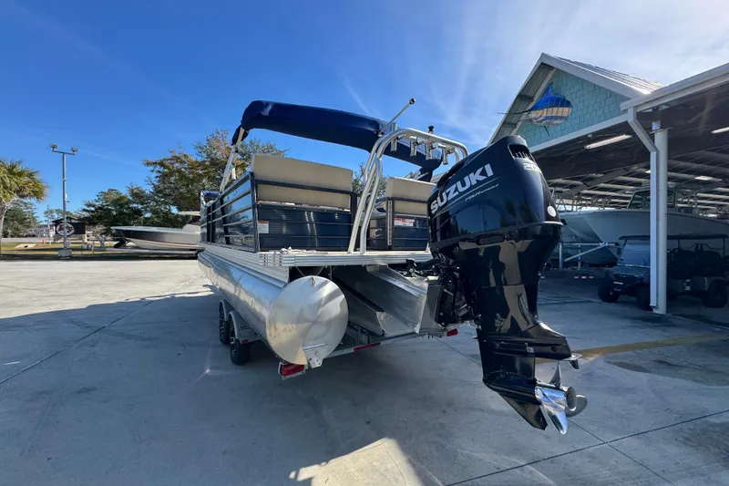 Slide: The Image of 2022 Crest Classic LX 240 SLRC pontoon boat with Suzuki outboard motor in marina setting. - 17