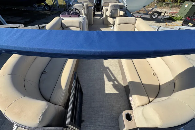 Slide: The Image of 2022 Crest Classic LX 240 SLRC pontoon boat with beige seating and blue canopy. - 19