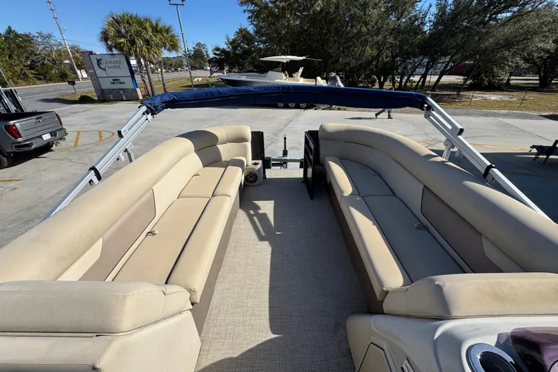 Slide: The Image of 2022 Crest Classic LX 240 SLRC pontoon boat with beige seating and blue canopy. - 21
