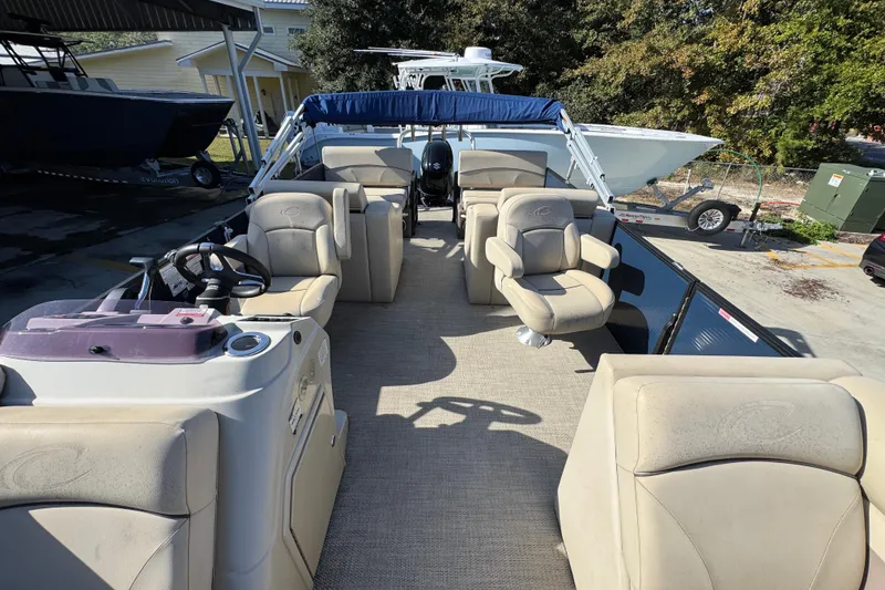 Slide: The Image of 2022 Crest Classic LX 240 SLRC pontoon boat with beige seating and steering console. - 24