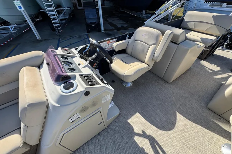 Slide: The Image of 2022 Crest Classic LX 240 SLRC boat interior with beige seating and control panel. - 25