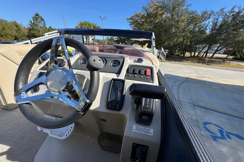 Slide: The Image of 2022 Crest Classic LX 240 SLRC boat dashboard with steering wheel and controls. - 29