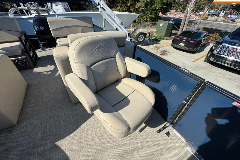 Slide: The Image of 2022 Crest Classic LX 240 SLRC boat seat with armrests, parked in a lot. - 31