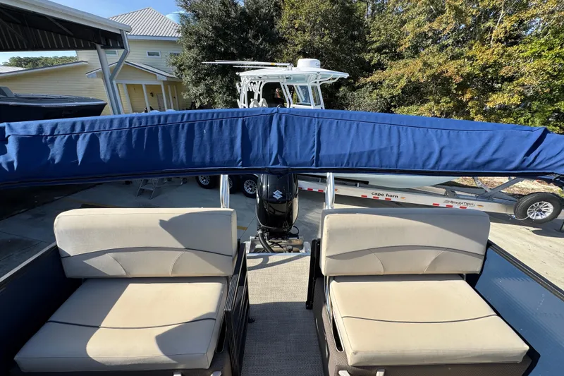 Slide: The Image of 2022 Crest Classic LX 240 SLRC pontoon boat with blue canopy and beige seating. - 35