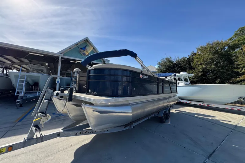 Slide: The Image of 2022 Crest Classic LX 240 SLRC pontoon boat on trailer at marina. - 4