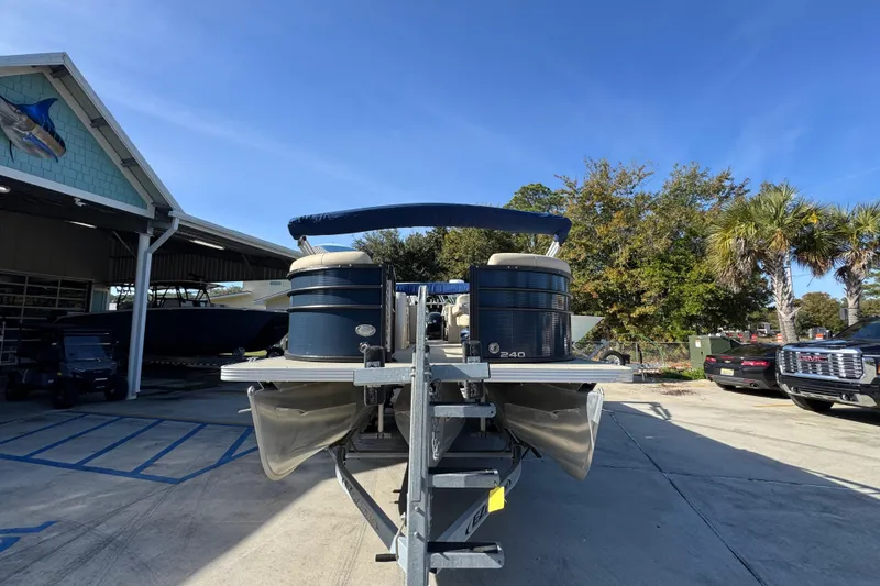 Slide: The Image of 2022 Crest Classic LX 240 SLRC pontoon boat on trailer, parked outdoors. - 6