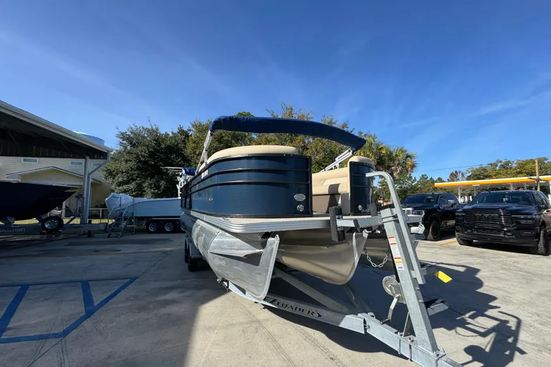 Slide: The Image of 2022 Crest Classic LX 240 SLRC pontoon boat on trailer, parked outdoors. - 7