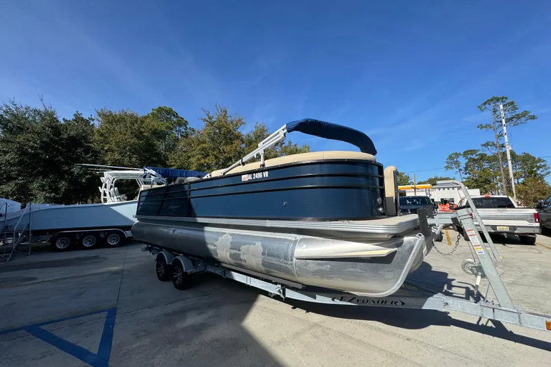 Slide: The Image of 2022 Crest Classic LX 240 SLRC pontoon boat on trailer, parked outdoors. - 8