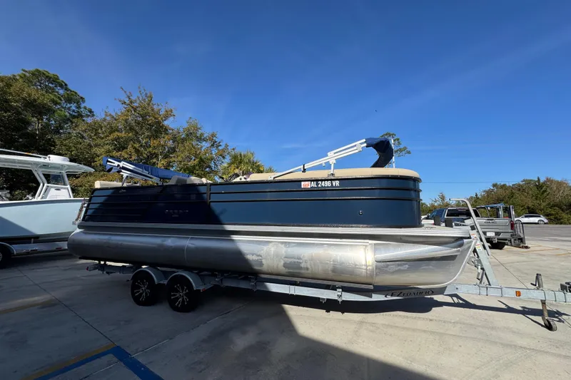 Slide: The Image of 2022 Crest Classic LX 240 SLRC pontoon boat on trailer, parked outdoors. - 9