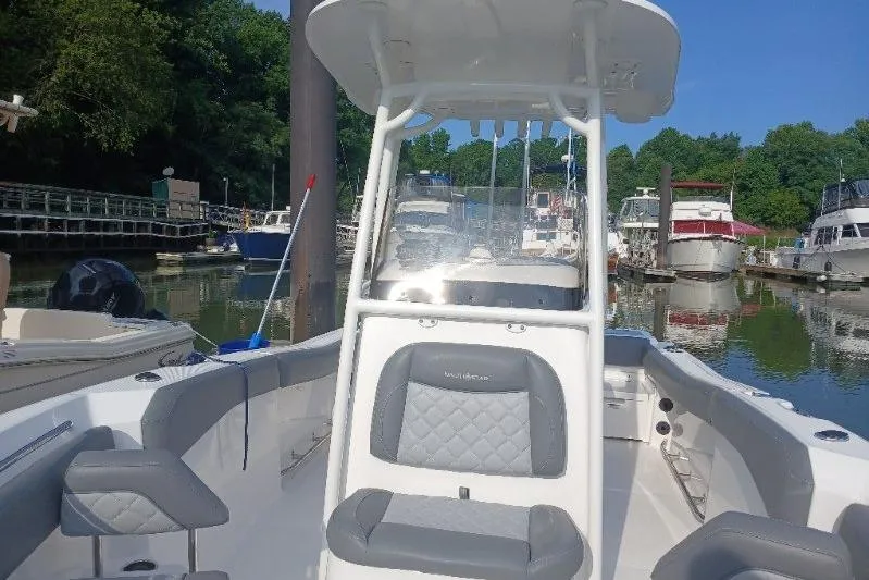 Slide: The Image of 2024 NauticStar 222L Offshore boat docked in a marina, featuring sleek seating and console. - 5