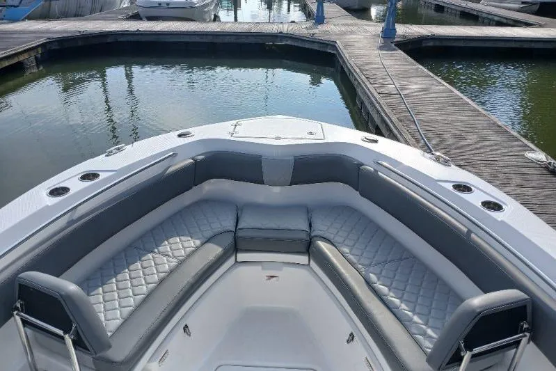 Slide: The Image of 2024 NauticStar 222L Offshore boat with spacious seating at a marina dock. - 7
