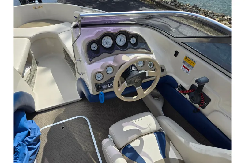 Slide: The Image of 2001 Glastron GX 205 boat interior with steering wheel and dashboard controls. - 12