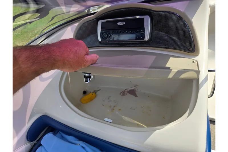 Slide: The Image of 2001 Glastron GX 205 boat dashboard with open glove compartment and stereo system. - 14