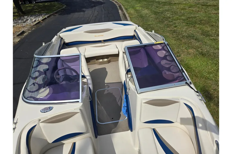 Slide: The Image of 2001 Glastron GX 205 boat interior with purple-tinted windshields and white-blue seating. - 17