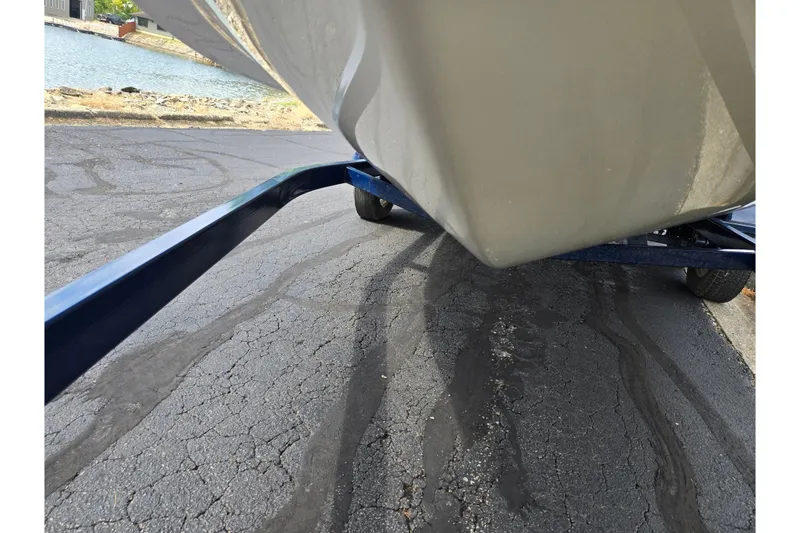 Slide: The Image of 2001 Glastron GX 205 boat on trailer near water, asphalt surface visible. - 7