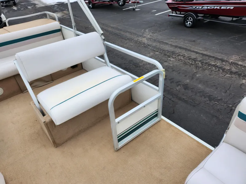 Slide: The Image of Pontoon boat interior with white seating, Sweetwater 180 model, 2000, in a parking lot. - 10