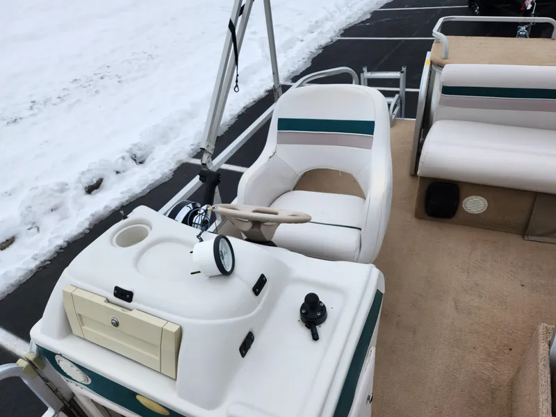 Slide: The Image of Sweetwater 180 boat interior, 2000 model, featuring helm and seating, parked on snowy pavement. - 11