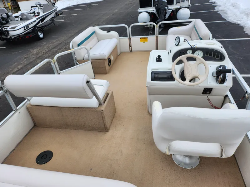 Slide: The Image of Sweetwater 180 pontoon boat interior, 2000 model, featuring white seating and steering console. - 15