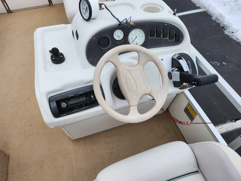 Slide: The Image of Steering console of a 2000 Sweetwater 180 boat with gauges and controls. - 16