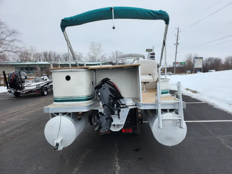 Slide: The Image of Sweetwater 180 pontoon boat, 2000 model, with outboard motor and canopy, parked on snowy pavement. - 2