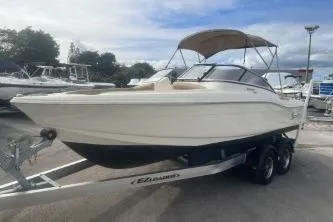 Slide: The Image of 2022 Scout 210 Dorado boat on trailer, parked outdoors under cloudy sky. - 4