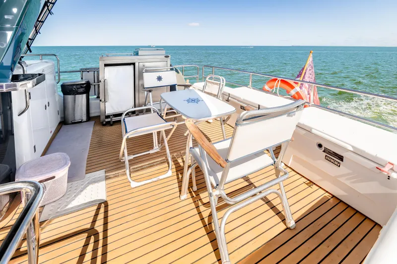 Slide: The Image of Deck of 2023 Sirena 58 yacht with seating, ocean view, and flag. - 11