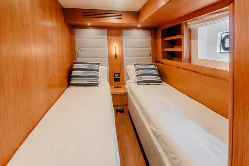 Slide: The Image of Luxurious twin cabin interior of 2023 Sirena 58 yacht with wooden finish and striped pillows. - 28