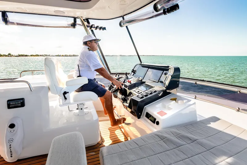 Slide: The Image of Person steering 2023 Sirena 58 yacht on open water, sunny day, modern helm. - 5