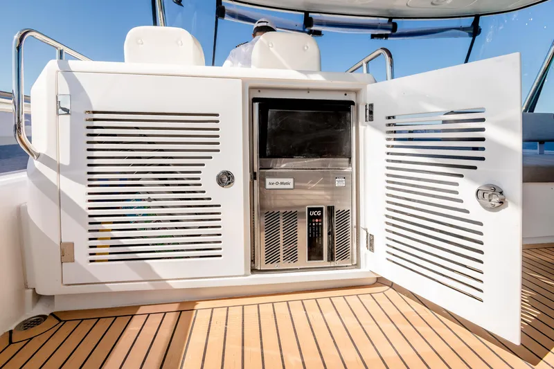 Slide: The Image of Open storage compartment on 2023 Sirena 58 yacht, featuring an ice maker and teak flooring. - 9