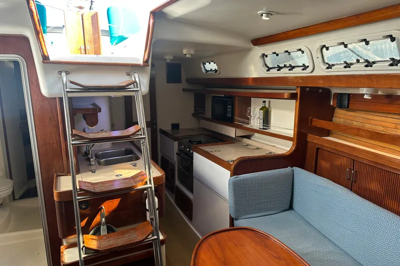 Slide: The Image of Interior of 1994 Catalina Morgan 38 sailboat with kitchen, seating, and wooden accents. - 10