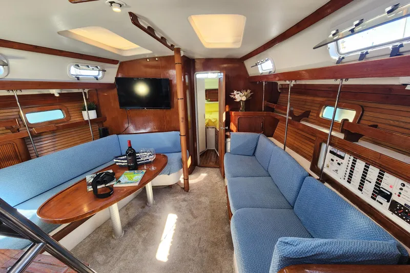 Slide: The Image of Interior of 1994 Catalina Morgan 38 sailboat with blue seating and wooden accents. - 11