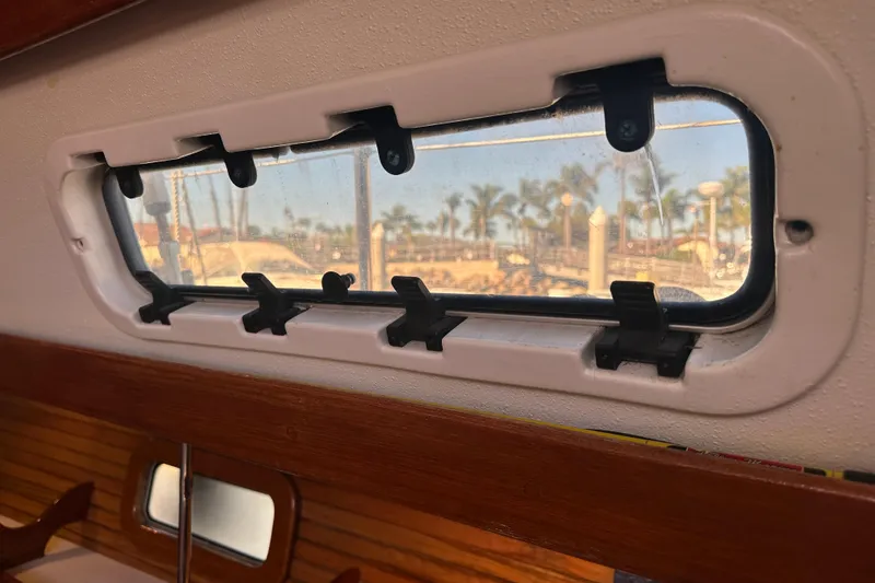 Slide: The Image of Port window view from 1994 Catalina Morgan 38 sailboat, showcasing marina and palm trees. - 12