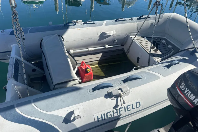 Slide: The Image of Inflatable boat with Yamaha motor, docked on calm water, featuring a red fuel container. - 25