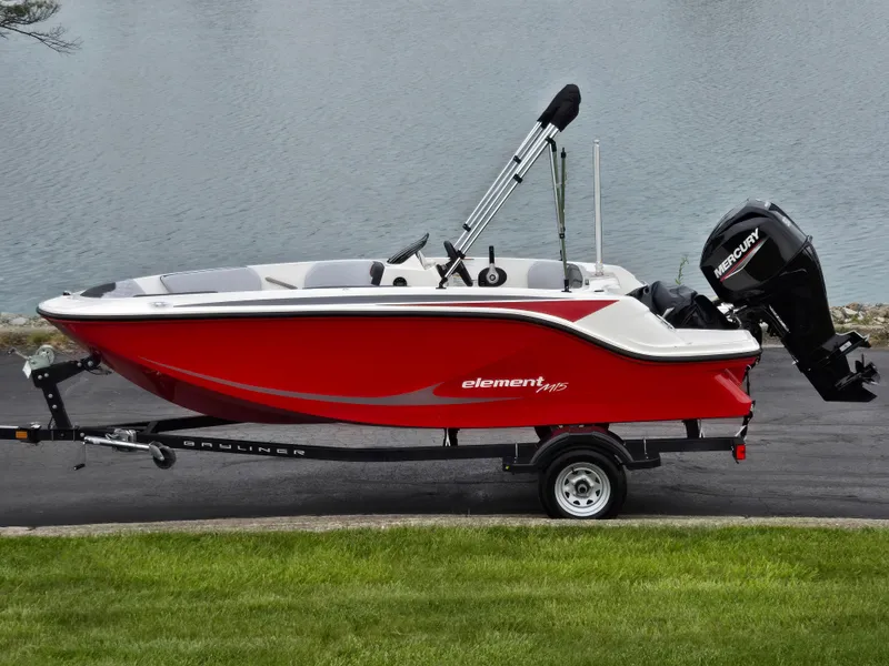 The Image of 2022 Bayliner Element M15 boat in red on a trailer by the water. - 0