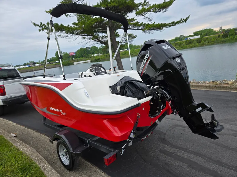 Slide: The Image of 2022 Bayliner Element M15 boat with Mercury engine on trailer by a lake. - 1