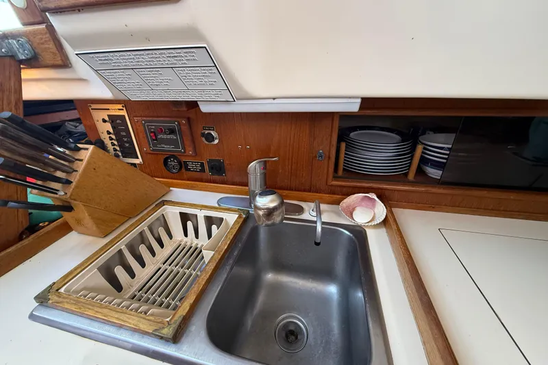Slide: The Image of 1985 Niagara Encore yacht kitchen with sink, knife block, and dish storage. - 14