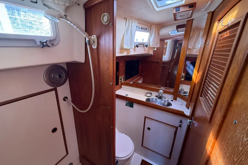 Slide: The Image of 1985 Niagara Encore yacht interior with wooden cabinetry, sink, and porthole windows. - 18