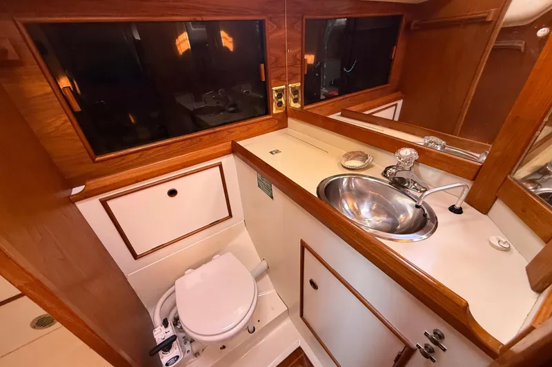Slide: The Image of 1985 Niagara Encore yacht bathroom with wood accents, sink, and toilet. - 19
