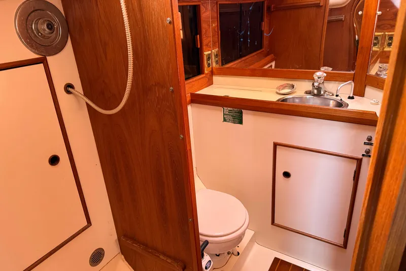 Slide: The Image of 1985 Niagara Encore boat bathroom with wooden cabinetry, sink, and toilet. - 20