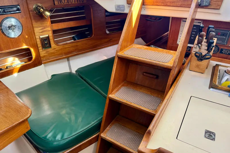 Slide: The Image of Interior of 1985 Niagara Encore sailboat with wooden steps and green cushioned seating. - 22