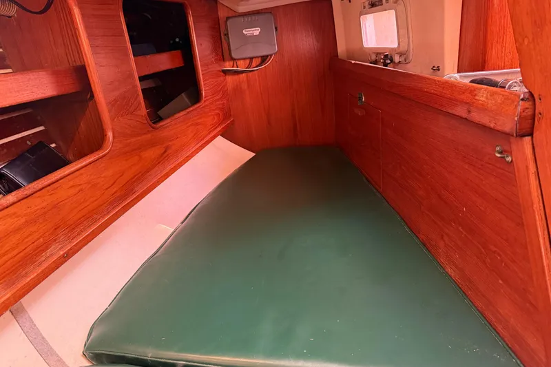 Slide: The Image of Interior cabin of 1985 Niagara Encore sailboat with green cushion and wooden finish. - 25