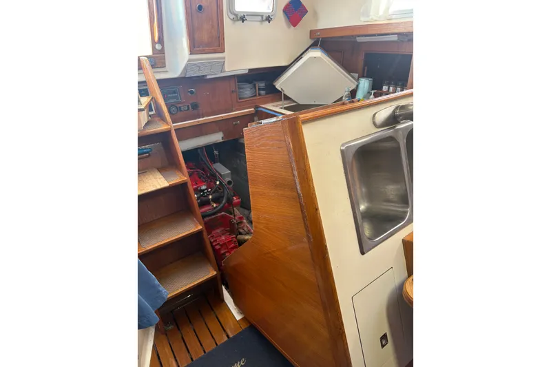 Slide: The Image of Interior of 1985 Niagara Encore sailboat with wooden stairs, sink, and engine compartment. - 26