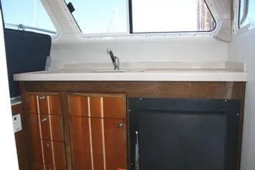 Slide: The Image of 2005 Ocean Sport Roamer 30' interior with wooden cabinetry and sink. - 13