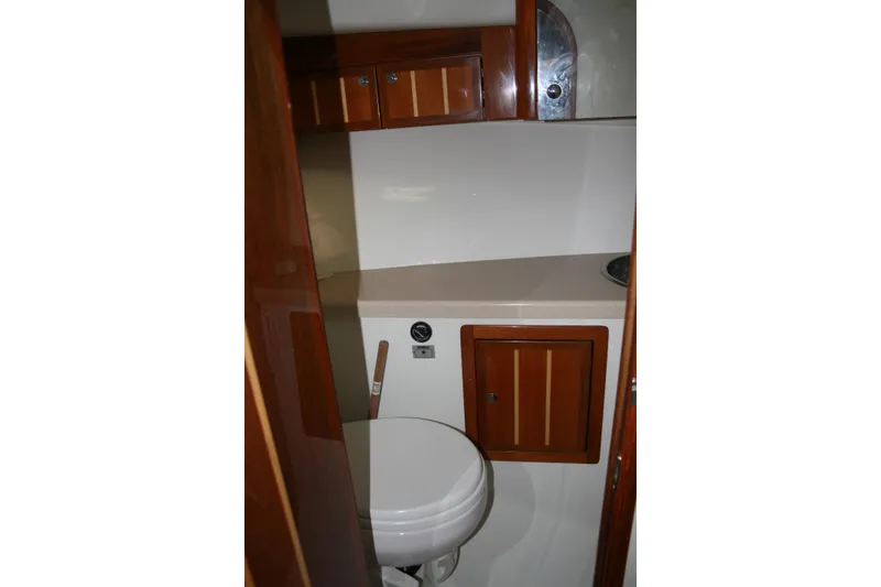 Slide: The Image of Compact bathroom in 2005 Ocean Sport 30' boat with wooden cabinetry and white fixtures. - 15