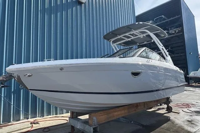 The Image of 2026 Cobalt R6 boat in storage, sleek design, blue building background. - 1