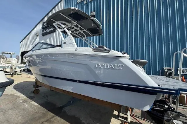 Slide: The Image of 2026 Cobalt R6 boat with sleek design, docked near a blue warehouse. - 5