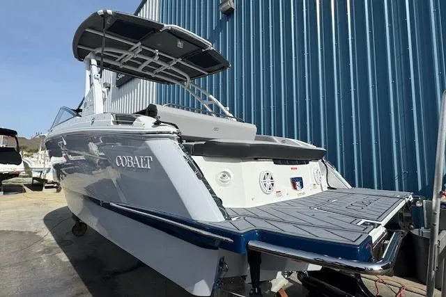 Slide: The Image of 2026 Cobalt R6 boat with sleek design, docked near a blue building. - 6