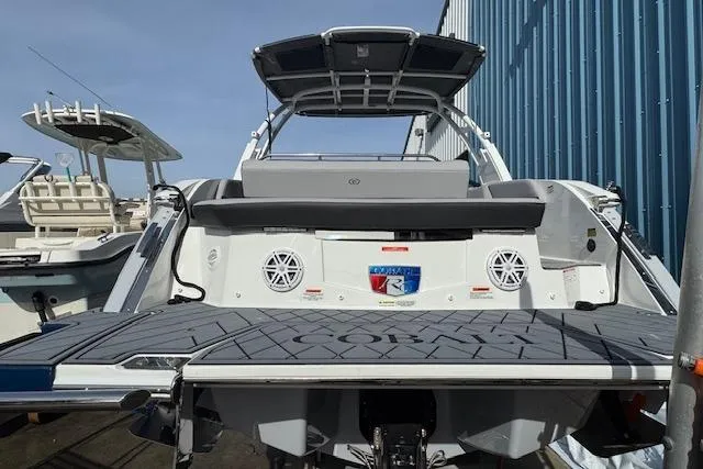 Slide: The Image of 2026 Cobalt R6 boat with sleek design, docked near a blue building. - 8